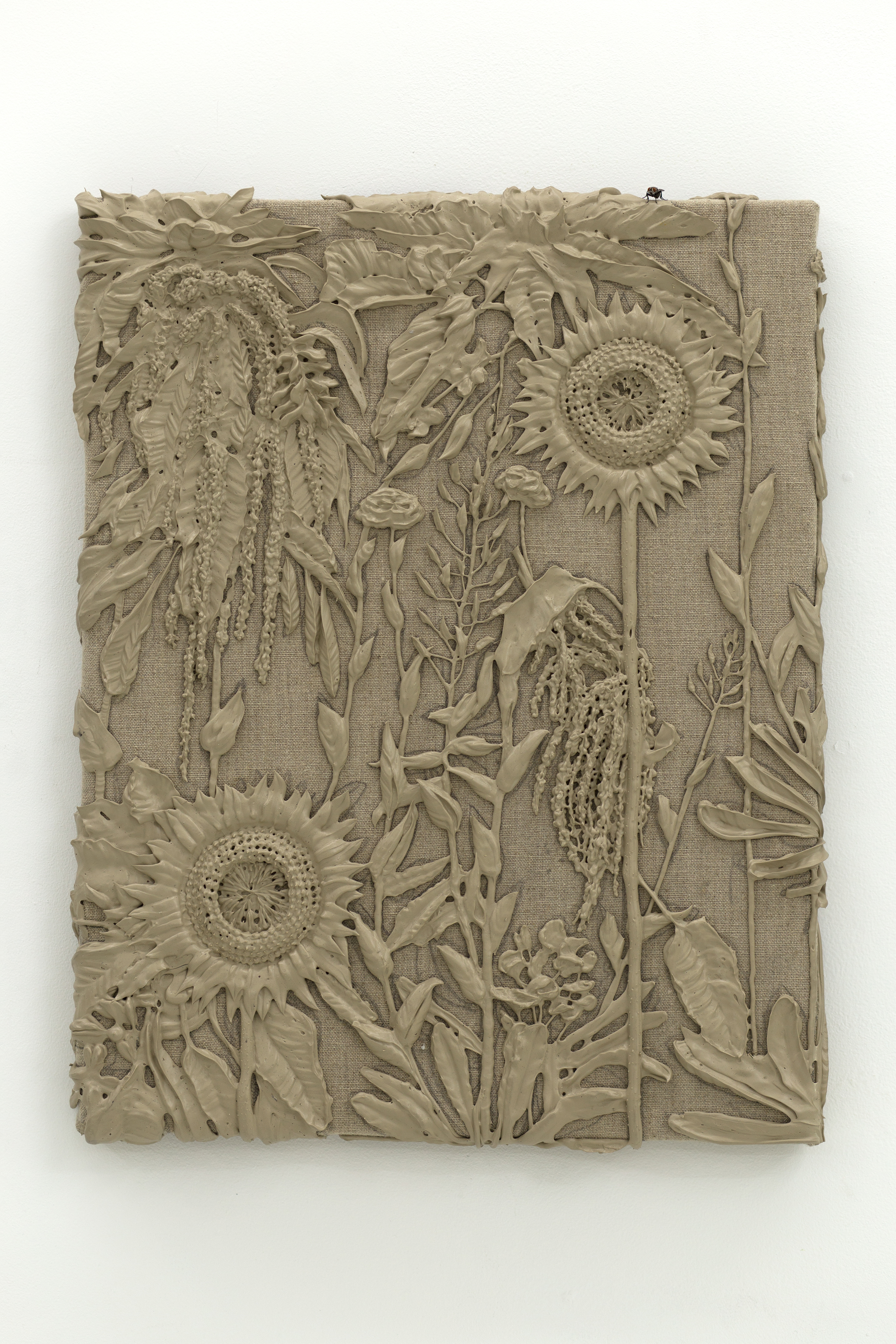 Brown monotone plastic painting of two sunflowers and assorted other plants